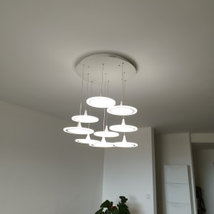 נברשת תלויה מהתקרה מעל שולחן עם סולם צהוב