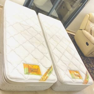 שני מזרנים לבנים עם כתמים על הרצפה