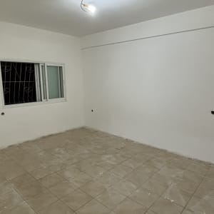 חדר צבוע עם קירות לבנים ורצפת אריחים