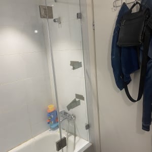 מקלחת עם דלת זכוכית, צעצועים על האמבטיה