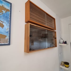 ארון עץ עם דלת זכוכית על קיר לבן