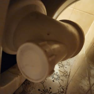 צינור פלסטיק מחובר לקיר עם אריחים