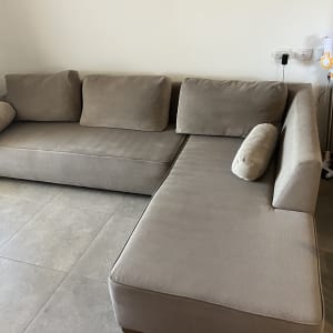 ספה אפורה עם כריות על רצפת אריחים