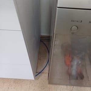 צינור כחול ליד מדיח כלים עם כפפות כתומות