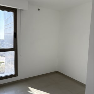 קירות לבנים צבועים בחדר ריק עם חלון