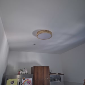 מנורה עגולה על תקרה במטבח עם ארונות ומקרר