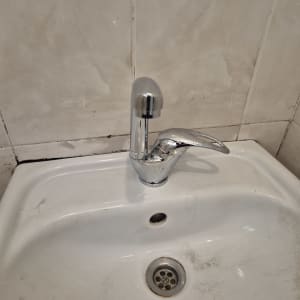 ברז וכיור בחדר אמבטיה עם כתמי לכלוך