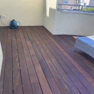 רצפת דק עץ עם צינור מים מגולגל בפינה