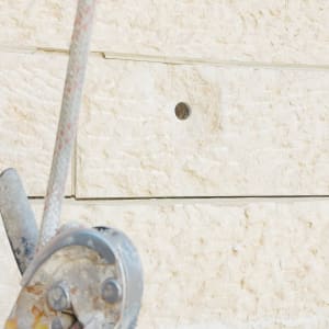 קידוח חור לחיזוק אריח אבן בחזית בניין באמצעות סנפלינג