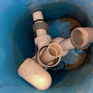 חלקי צנרת פלסטיק בתוך דלי כחול