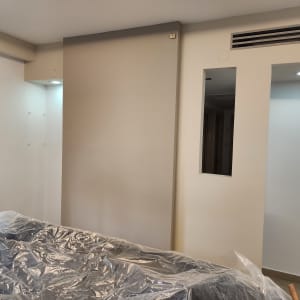 קיר צבוע בצבע בהיר עם רהיט מכוסה בניילון