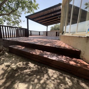 דק עץ עם פרגולה ליד חלון זכוכית ועץ