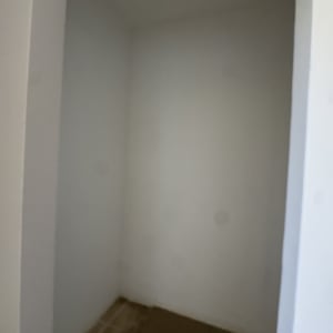 חדר קטן עם קירות לבנים ורצפת אריחים