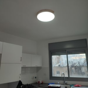 מטבח עם ארונות לבנים, כיור וברז מותקנים