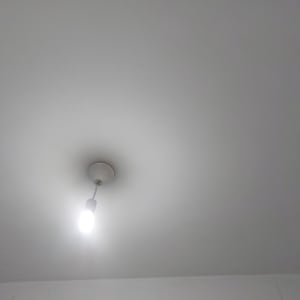 תקרה צבועה בלבן עם מנורה תלויה