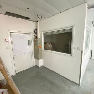 קירות לבנים עם חלון ודלת, רצפה אפורה