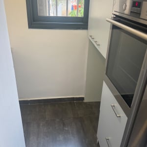 קירות מטבח צבועים בלבן לצד ארונות מטבח מותקנים