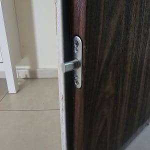 מנעול בדלת עץ כהה עם רצפת אריחים