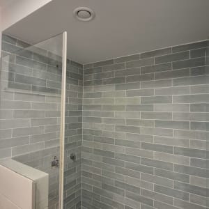 חדר מקלחת עם אריחים אפורים על הקירות