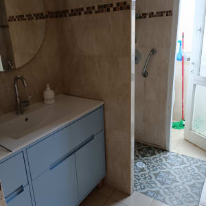 חדר אמבטיה עם אריחים חדשים, כיור ומקלחת