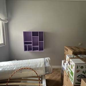 קופסאות קרטון ומדף סגול מותקן על הקיר