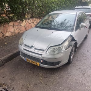 רכב עם נזק לפגוש הקדמי חונה ברחוב