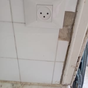 שקע חשמלי על קיר אריחים לבנים