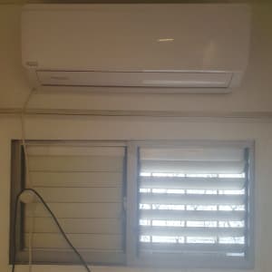 יחידת מיזוג אוויר מותקנת על קיר מעל חלון