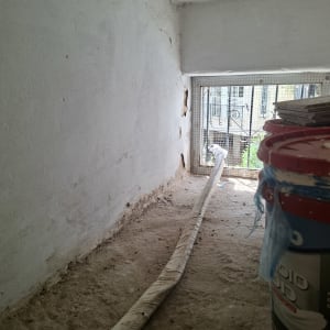 צינור ומיכל צבע בחלל סגור עם קיר לבן