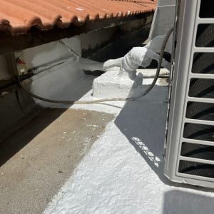 איטום גג עם חומר לבן ליד צינורות ומזגן