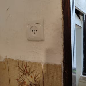 שקע חשמלי בקיר עם טיח מתקלף