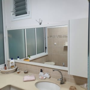 חדר אמבטיה עם כיור, מראה וחפצים שונים