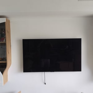 ארונות עץ לבנים עם טלוויזיה תלויה על הקיר