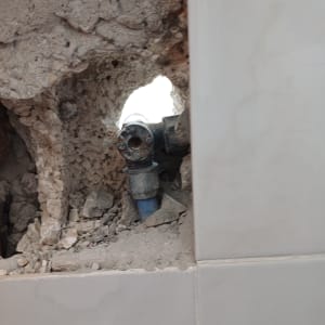 צינור מים חשוף בקיר שבור עם חיבורים