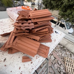 ערימת רעפים על גג עם נוף עירוני ברקע