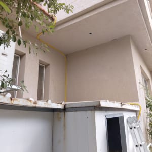 התקנת צינור גז צהוב לאורך קיר חיצוני של מבנה