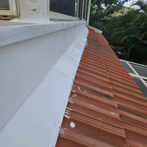 איטום גג עם חומר לבן על רעפים אדומים