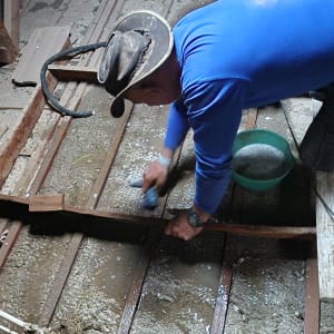 אדם מנקה גג עץ עם מברשת