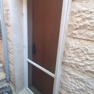 מסגרת אלומיניום לדלת עץ בכניסה לבית