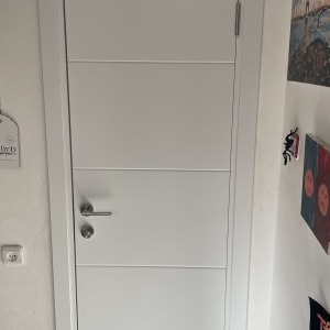 דלת לבנה עם שלט יציאה ירוק מעליה