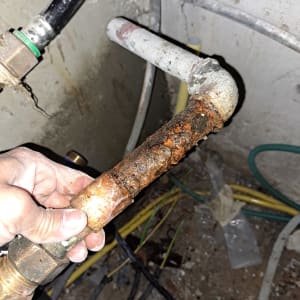 צינור חלוד מוחזק ביד של אינסטלטור