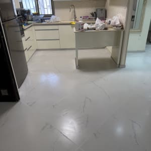 מטבח עם ארונות לבנים ורצפת שיש חדשה