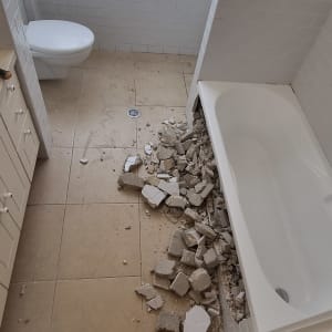 הריסות אריחים ליד אמבטיה במהלך שיפוץ