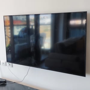 טלוויזיה תלויה על קיר עם כבלים חשמליים