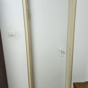 דלת לבנה עם ידית לבנה במסגרת בהירה