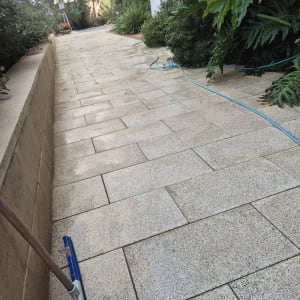ניקוי ושטיפה של ריצוף חוץ בצינור מים ומגב