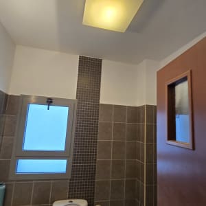 חדר אמבטיה עם שירותים, כיור וחלון