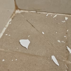 שברי צבע על רצפת אריחים בפינה