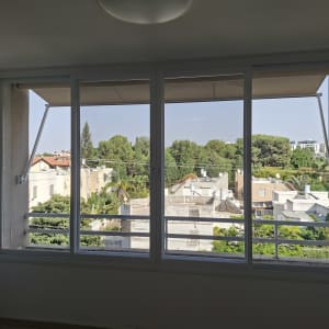 התקנת חלון הזזה גדול מאלומיניום לבן המשקיף למרפסת ולנוף