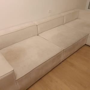 ספה בהירה בחדר עם רצפת עץ